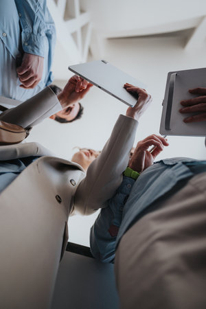 Business colleagues meet and review tablet and documents in a modern office, collaborative teamwork sceneの写真素材