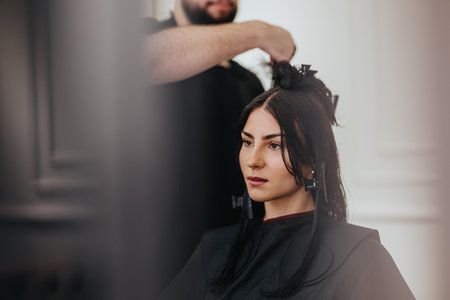 Woman in a beauty salon receiving a professional haircut and hair styling sessionの写真素材