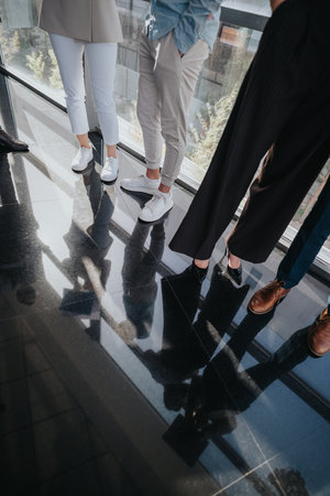 Group of professionals standing together in a modern office building with a reflective floorの写真素材