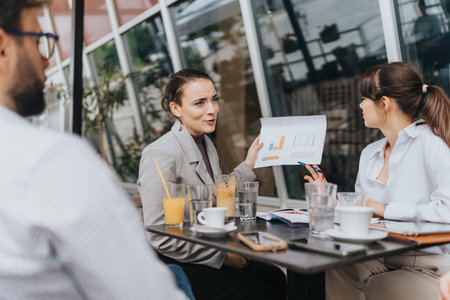 Team members discussing data and strategy at a cafe during a meetingの写真素材