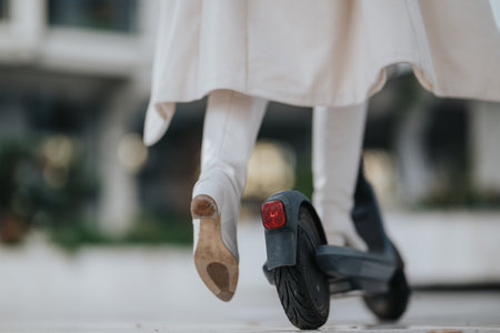 Person in white coat rides an electric scooter, seen from behind, urban mobility and styleの写真素材