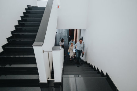 Group of people ascending a modern staircase in a bright, minimalist office building for a dynamic workplace sceneの写真素材