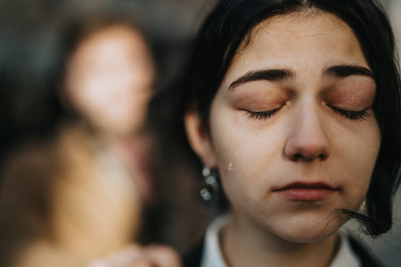 Close-up portrait of a sad woman with a tear on her cheek, conveying emotion and introspectionの写真素材