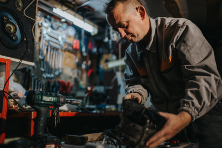 Mechanic in a workshop using a power drill on a mechanical partの写真素材