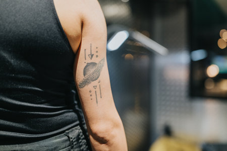 Geometric tattoo on forearm with planet motif and abstract lines in an urban settingの写真素材