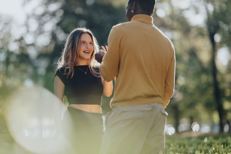 Smiling woman and man in a park share a laugh during a sunny outdoor momentの写真素材