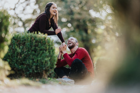 Couple laughing in a sunny park, enjoying time together outdoorsの写真素材