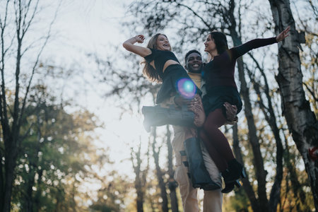 Friends lift each other in a joyful outdoor moment in the park during autumn sunlight
