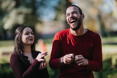 Two friends laughing in a sunny park, enjoying a joyful outdoor moment
