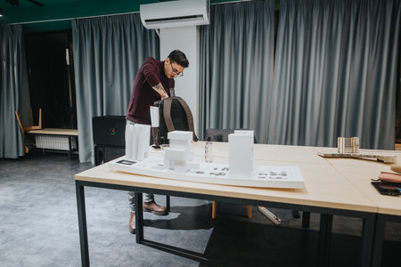 Designer at a collaboration center builds architectural models with white foam blocks and sketches