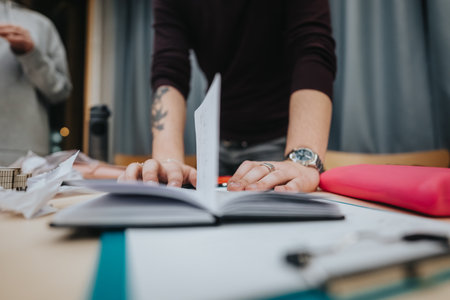 Person organizes papers at a desk during a focused study sessionの写真素材