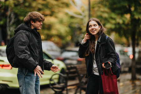 Teenage friends talk on a city street in autumn, with backpacks and a shopping bag
