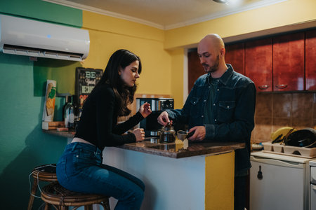 Couple prepares coffee at a colorful kitchen counter in a casual home settingの写真素材