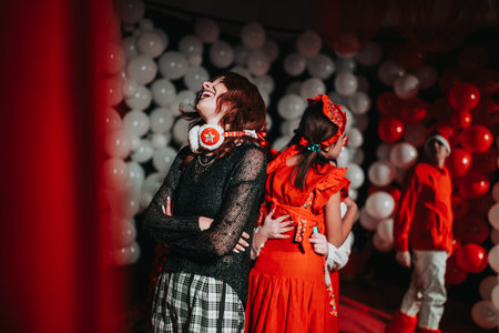 Festive Christmas theater performers pose among red and white balloons in a lively show
