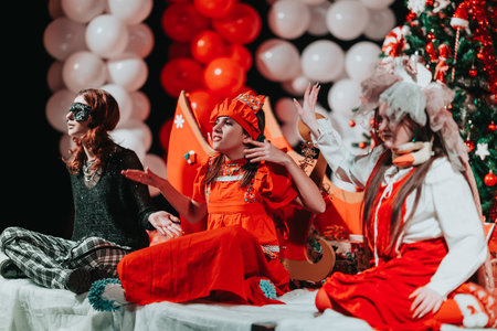 Children perform a festive Christmas theater show on a colorful, balloon-filled stage decorated for...