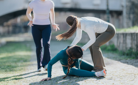 Supportive workout moment outdoors as friends help child during a fitness sessionの写真素材