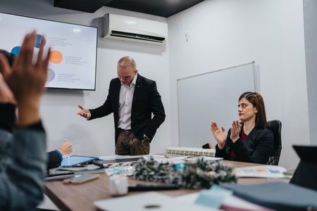 Business meeting in a modern office with a speaker and a woman clapping during a presentation