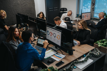 Busy open-plan office scene with colleagues working at desks and computers