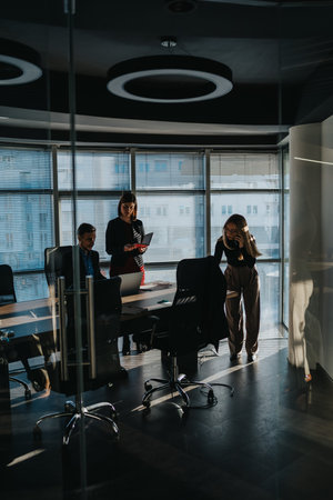 Business team in a modern office discusses project near the conference table and glass walls