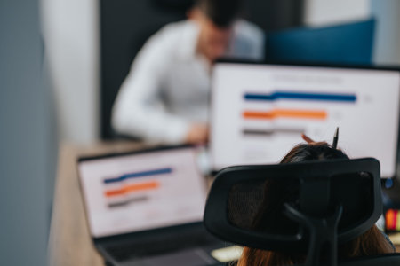Business Team at Desks Analyzing Charts on Monitors in a Modern Office