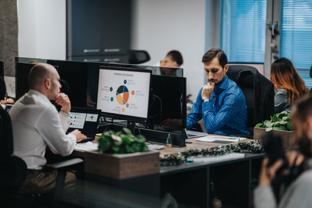 Business professionals analyze data at a shared desk in a modern office environment
