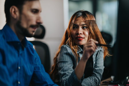Two business employees collaborate in a modern office, discussing a project with a pen in hand