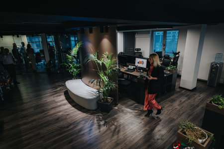 Professional office lobby scene with a woman walking past desks, plants, and modern reception area
