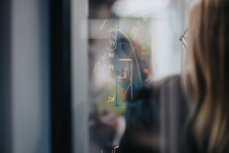 Business planning session shown on a glass board with calendar, dates, and notesの写真素材