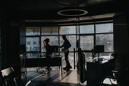 Business professionals collaborate at a modern office desk by large windows during daylight