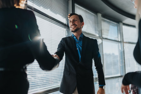 Business professional shakes hands in modern office, signaling partnership and successful meeting...