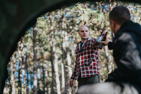 Two friends share a drink in a forest setting, captured in a casual outdoor momentの写真素材