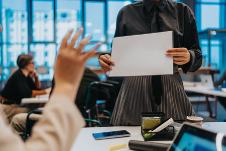 Presenter holds organizational chart while colleagues discuss in a modern office meeting briefing.