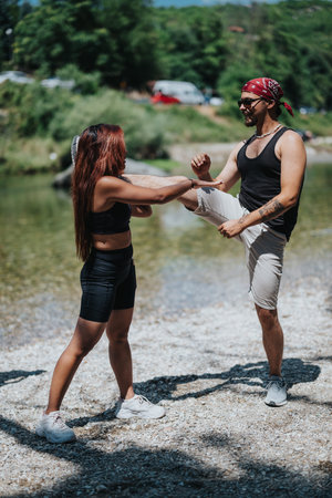 Two friends training by the riverside in summer, balancing kicks and staying active