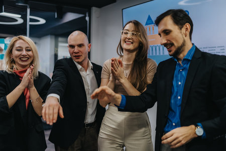 Professional group of colleagues celebrate and smile during a team recognition moment in the office