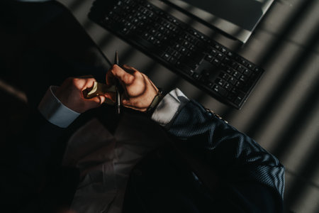 Focused desk work: close up of hands writing with sticky notes and a keyboard at the deskの写真素材