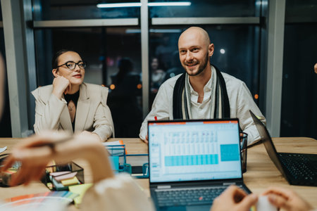 Business meeting between colleagues in a modern office with laptops and friendly expressions