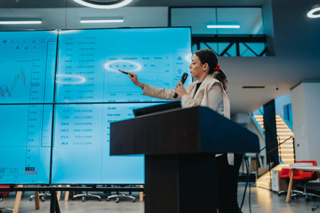 Female presenter delivers a data-driven stock market briefing in a modern conference room with large...