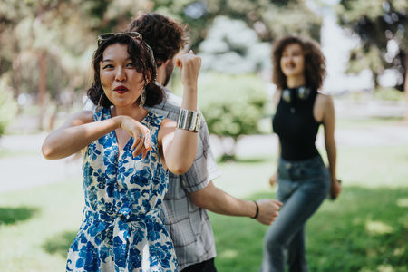 Friends dancing in a sunny park in stylish summer outfits, capturing carefree, joyful moments