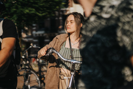 Friends walking with bicycle in sunlit Netherlands street near parked bikes and historic buildings