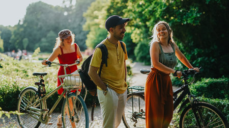 Friends cycling and walking together in a sunny Netherlands park enjoying summer outdoors