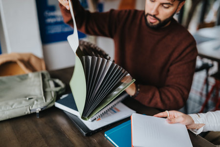 Business colleagues reviewing folders and notebooks during a casual meeting at a wooden table