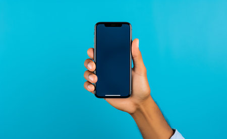 Cropped view of woman holding smartphone with blank screen isolated on blueの素材