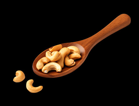 Roasted cashew nuts in wooden spoon isolated on transparent background.の素材