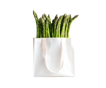 Bunch of fresh green asparagus in white shopping bag isolated on transparent backgroundの素材