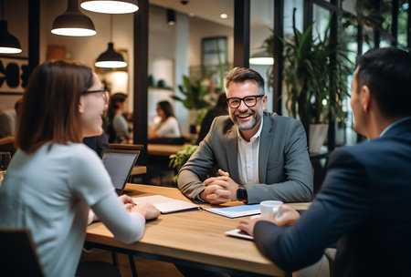 Group of business people working together in office. Businessman and businesswoman sitting at table and talking.の素材