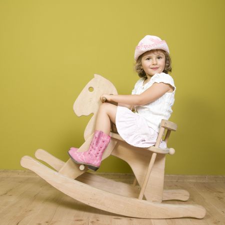 Little country girl playing with rocking horseの写真素材