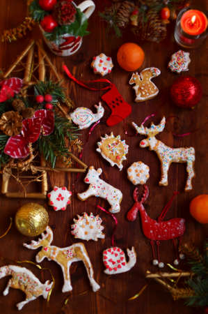 Christmas cookies made by kids on the wooden table with Christmas-tree decorationsの写真素材