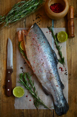 Eviscerated fresh trout with lime, rosemary and spicery on the preparation tableの写真素材