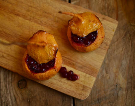 Turnip filled (stewed) with cranberries and honey on the wooden hardboardの写真素材