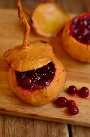 Turnip filled (stewed) with cranberries and honey on the wooden hardboardの写真素材